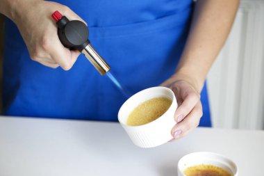 Creme Brulee tatlı bir meşale kullanarak Caramelizing