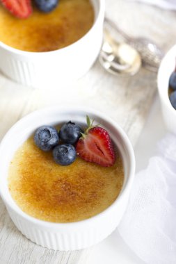 Creme brulee - geleneksel Fransız üstte caramelised şekerli vanilya krem tatlı. Creme Brulee tatlı çilek, yaban mersini ve taze nane yaprakları ile