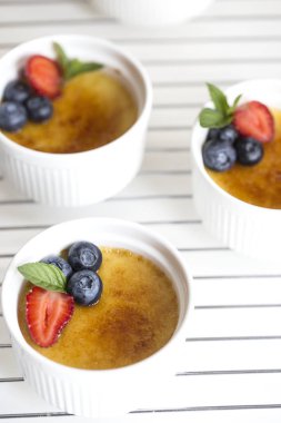 Creme brulee - geleneksel Fransız üstte caramelised şekerli vanilya krem tatlı. Creme Brulee tatlı çilek, yaban mersini ve taze nane yaprakları ile