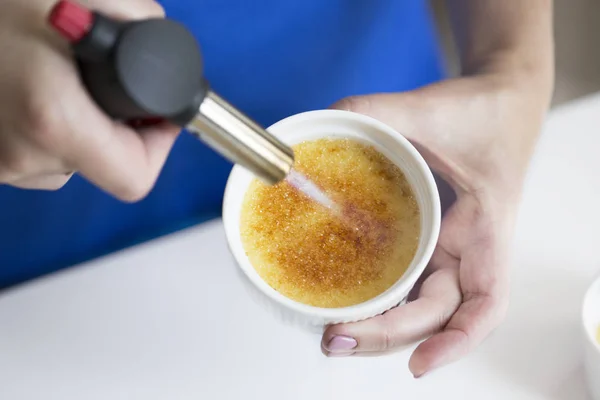 Creme Brulee tatlı bir meşale kullanarak Caramelizing