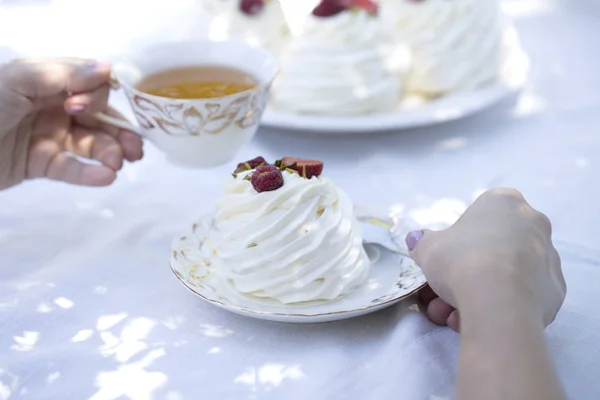 Pavlova cakes with cream and fresh summer berries