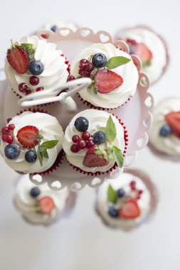 renkli meyveleri ile cupcakes. Buttercream ve taze çilek ile renkli kek