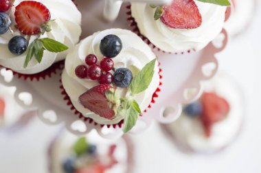 renkli meyveleri ile cupcakes. Buttercream ve taze çilek ile renkli kek