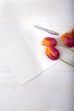 Yükü turuncu ve sarı renkli bahar Lale çiçek ve boş kağıt kartı bir buket Beyaz ahşap masa üst üzerinde gün anne veya kadınlar için vurdu. Düz yatıyordu üstten görünüm stili.