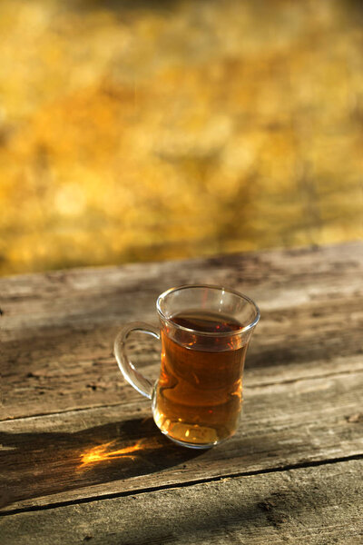cup of tea on balcony with nature view. Cup of autumn tea. A cup of tea standing on a outdoor desk in a beautiful autumn scenery. tea, fall, landscape, cup, outdoor drink