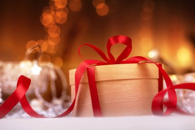 Metniniz için kopya alanı ile Noel tatil kompozisyon. Noel hediye kutusunda kırmızı kurdele ile Kraft kağıt. kırmızı kurdele ile yuvarlak hediye kutusu