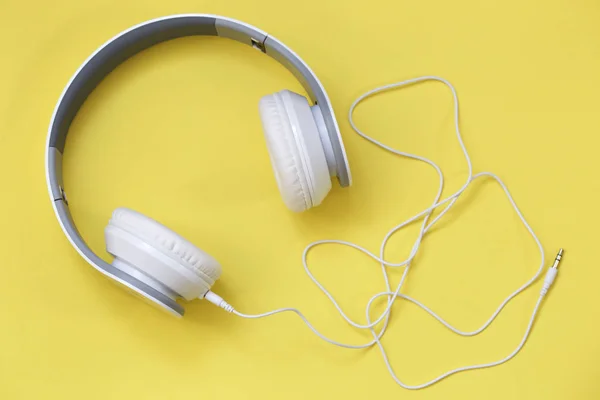  sarı zemin üzerine beyaz kulaklık. Müzik konsepti. Sarı arka plan üzerinde kulaklık.