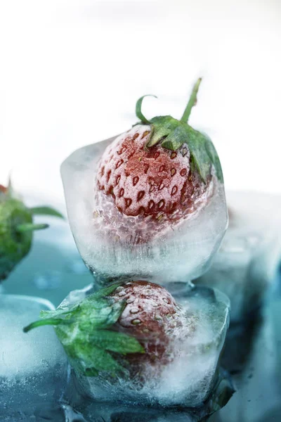 Buzda donmuş çilek kapatın. Buz küpü ve çilek