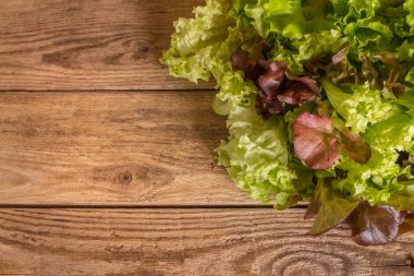 Ahşap masanın üstüne yığılmış alan yeşil taze karışık salata