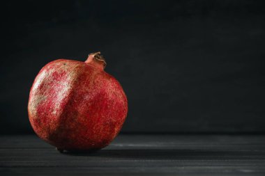 Siyah ahşap zemin üzerine nar meyve. Sağlıklı gıda kavramı