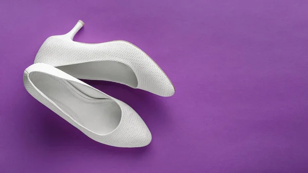 紫色の背景にシンプルな白の結婚式の靴 — ストック写真