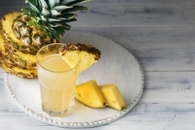 Ananas taze cam ahşap bir masa üzerinde gri beton arka plan üzerinde Önden Görünüm sıkılmış suyu