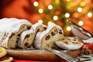 Stollen, geleneksel Alman Noeli Maya kek üzümlü masada, köknar ağacı bokeh arka plan üzerinde ışıklar
