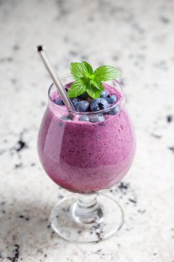 Mermer masa üzerinde yeniden kullanılabilir metal çelik saman ile cam içecek Blueberry smoothie