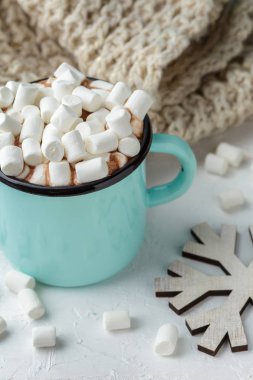Mavi metal bir fincan kakao veya sıcak çikolata şekerleme kış dekorasyonu ile masada, şube corton çiçek, örgü battaniye ve ahşap Noel süsler