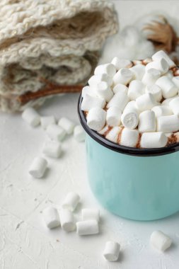 Mavi metal bir fincan kakao veya sıcak çikolata şekerleme kış dekorasyonu ile masada, şube corton çiçek, örgü battaniye ve ahşap Noel süsler