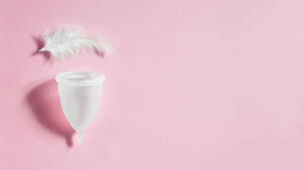 月経カップとピンク色の背景上の白い鳥の羽 期間中に別の女性の衛生用品 女性医療の概念 — ストック写真