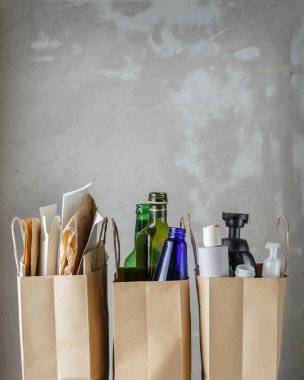 Üç kağıt poşet sıralanmış evsel atıklarla birlikte