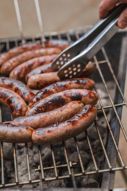 Barbekü ızgarasında ızgara sosis.