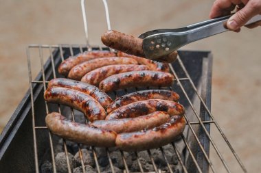 Barbekü ızgarasında ızgara sosis.