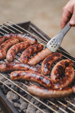 Barbekü ızgarasında ızgara sosis.