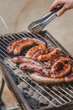 Barbekü ızgarasında ızgara sosis.