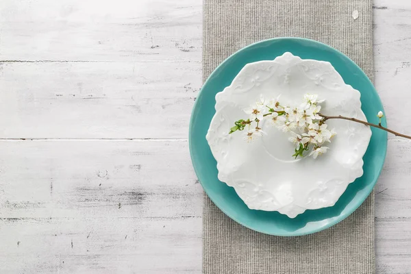 Spring tafel set met platen en witte bloemen — Stockfoto