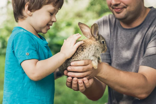 Le petit garçon tient un lapin à la ferme — Photo