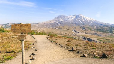 St. Helens Dağı 'nı ve Johnston Tepesi' nin izini ön planda bir bilgi işaretiyle izleyin.