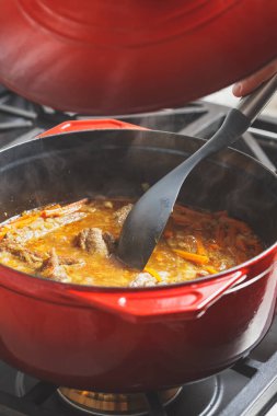 Evde pilav pişirme süreci. Kırmızı dökme demir Hollanda fırınına kapak koyuyoruz.