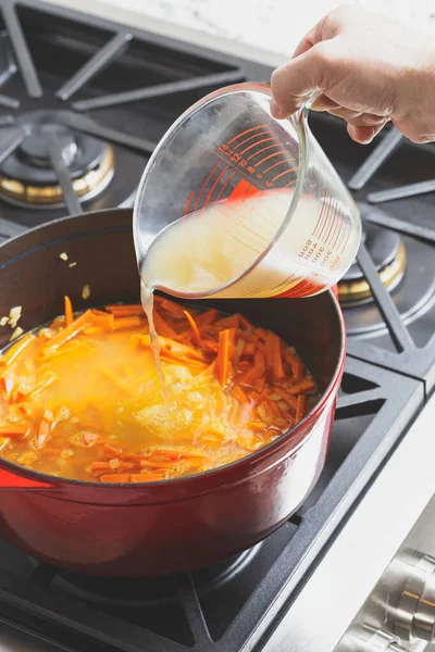 Brodo Pollo Viene Versato Forno Olandese Ghisa Con Carota Tritata — Foto Stock