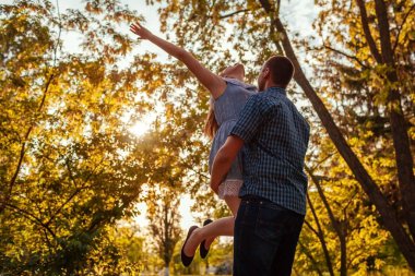 Mutlu çift bahar Park'ta ücretsiz duygu. Adam kız arkadaşı günbatımında elinde tutar. Kadın el kaldırdı. İnsanlar rahatlatıcı
