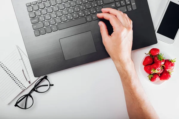 Üstten görünüm serbest çalışan adamın üstünde laptop notebook, smartphone, gözlük ve çerez Resepsiyon masasında çalışıyor. From home çalışma