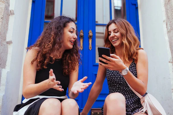 Şehirde Smartphone kullanırken chat yapan iki kadın arkadaşlarım. Söz ve Cafe cam kenarında oturan gülerek mutlu kızlar