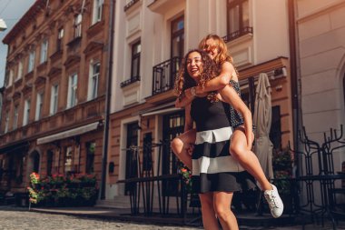 Onun en iyi arkadaşı şehir sokak sırtında taşıyan genç kadın. Gülen ve having fun mutlu genç kız öğrenciler. Yaz eğlence anlar