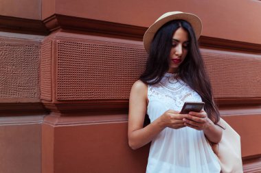 Açık havada akıllı telefon kullanan güzel turist kız. Orta Doğulu kadın sokakta navigator ile doğru şekilde arama