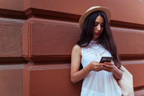 Açık havada akıllı telefon kullanan güzel turist kız. Orta Doğulu kadın sokakta navigator ile doğru şekilde arama