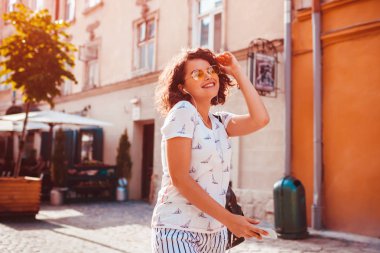 Güzel genç kız Smartphone kullanarak ve sokakta yürürken müzik dinlemek. Mutlu kadın dans ve having fun