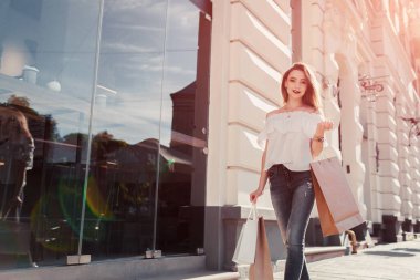 Alışveriş torbaları yaz aylarında caddenin üzerinde yürüyen güzel şık genç kadın. Mutlu kız tutan alımları. Alışveriş Merkezi