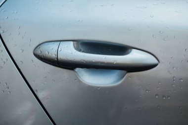 Modern araba kapıda baş. Üzerinde gri otomobil yağmurlu su damlaları