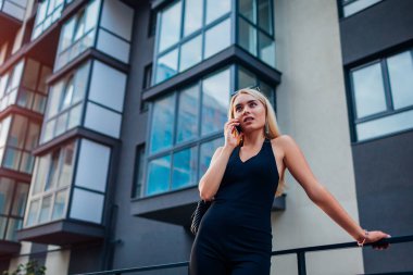 Genç Sarışın gerçek Ajan Smartphone'da modern şehirde bina tarafından söz eastate. İşkadını arama istemci. Müşteriler ile iletişim