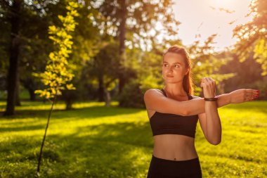 Genç sportif kadın yaz Park yapıyor. Vücudu germe sporcumuz. Egzersiz