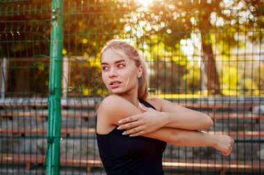 Yaz aylarında Sportsground üzerinde çalıştırmadan önce ısınma genç kadın atlet. Sportif erkek beden germe. Aktif yaşam tarzı