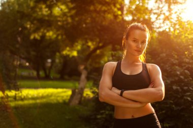 Kameraya el ile arayan genç sportif kadın yaz parkta geçti. Gülümseyen güçlü mutlu kız. Sağlıklı bir yaşam tarzı. Spor