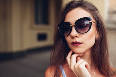 Açık portre genç güzel şık kadının şık güneş gözlüğü takıyor. Şehir moda. Makyaj. Yakın çekim
