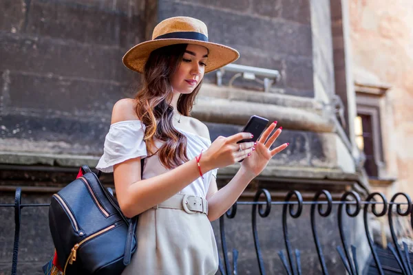 Genç turist kadın şu şekilde navigator smartphone kullanarak için arama. Şık gezgin kız eski şehir sokak yürüyüş