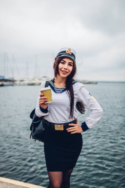 Deniz Akademi üniforma giyen deniz kenarında kahve içme üniversiteli kadın. Kız Odessa Limanı içinde iskelede yürüyüş