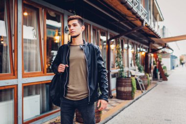 Genç kafeterya olarak şehir sokak üzerinde yürürken taşıma akustik gitar durumda adam. Hipster üniversite öğrencisi Müzik Akademisi