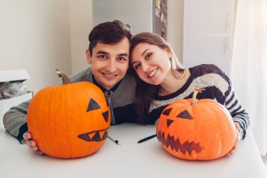 Genç yapma jack-o-lantern Cadılar Bayramı için mutfak çift. Mutlu bir adam ve kadın kabaklar tatil için hazırlanmış. Dekorasyon