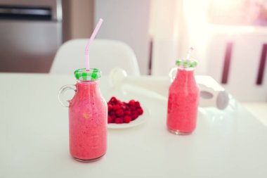 Meyveli smoothie mutfak masasının üstünde içmeye hazır iki şişe. Sağlıklı beslenme. Sportif gıda